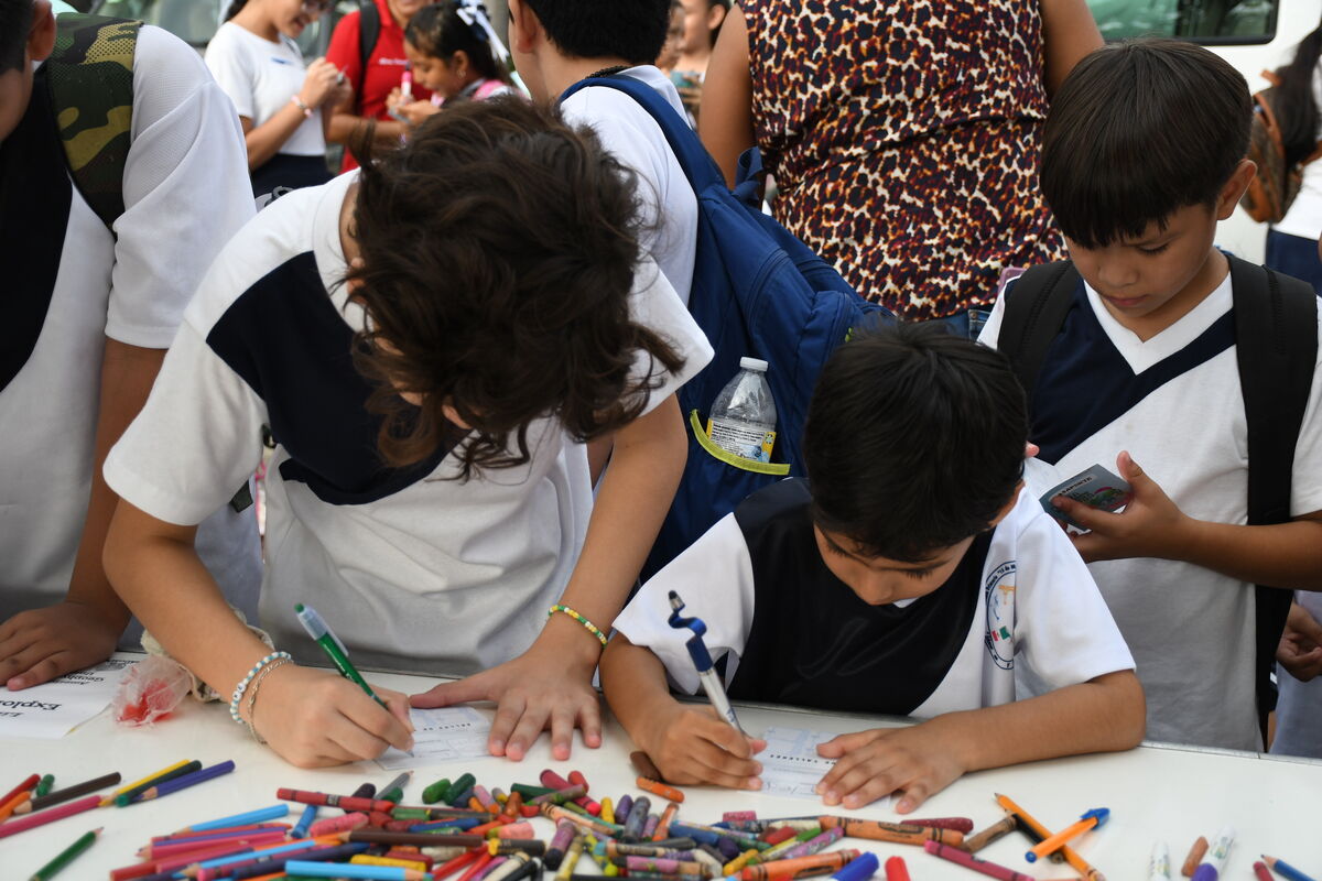 Niñas y niños coloreando en la Feria